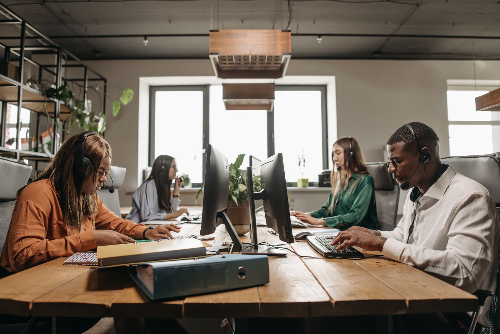 A team using headsets and computers in a bright office